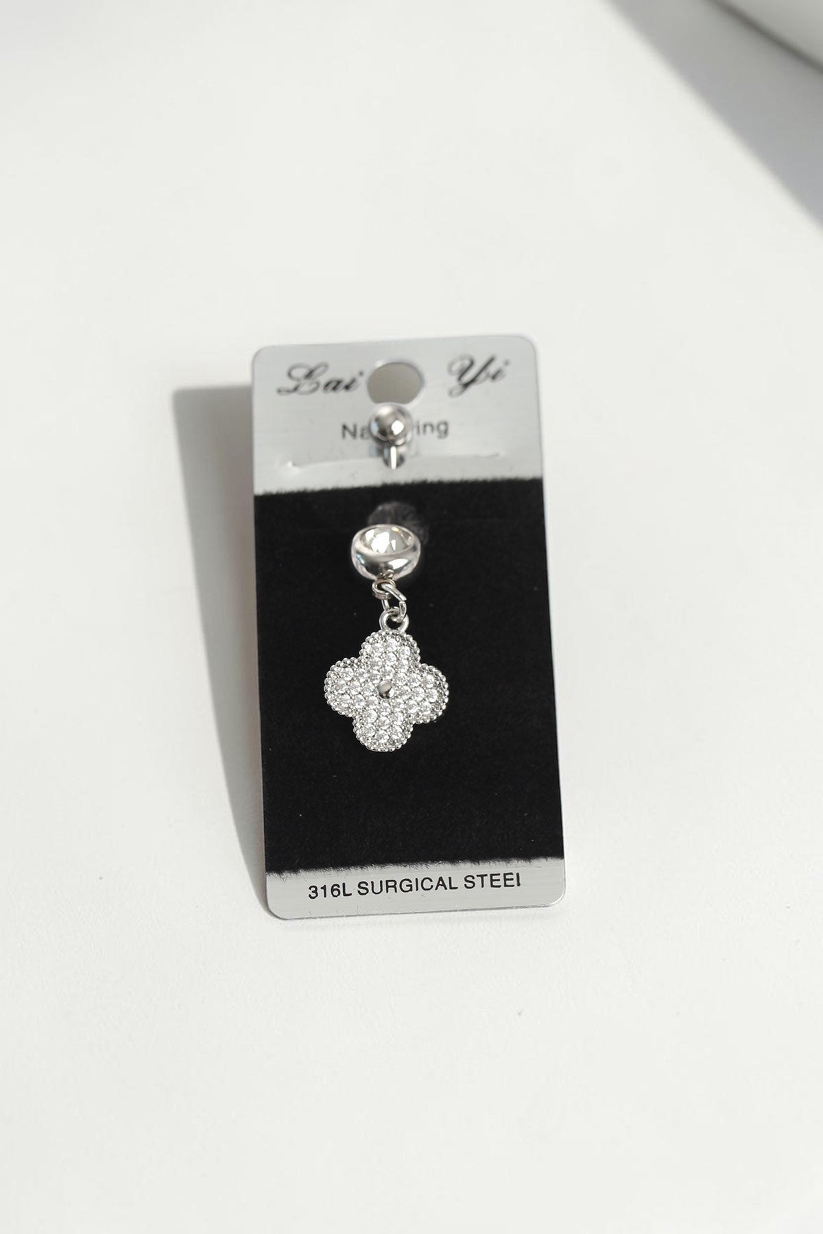 VORA HOUSE silver 316L surgical steel belly button piercing featuring a dangling clover charm with zircon stones.