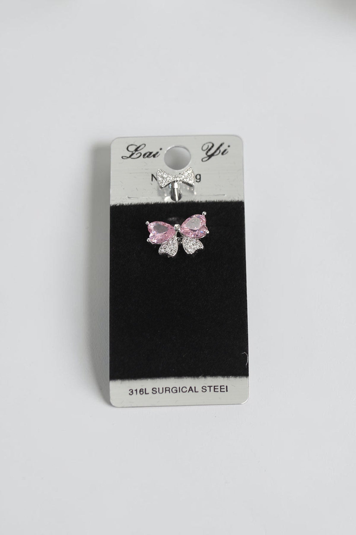 VORA HOUSE 316L surgical steel belly piercing featuring a pink zircon bow design with sparkling crystal accents.