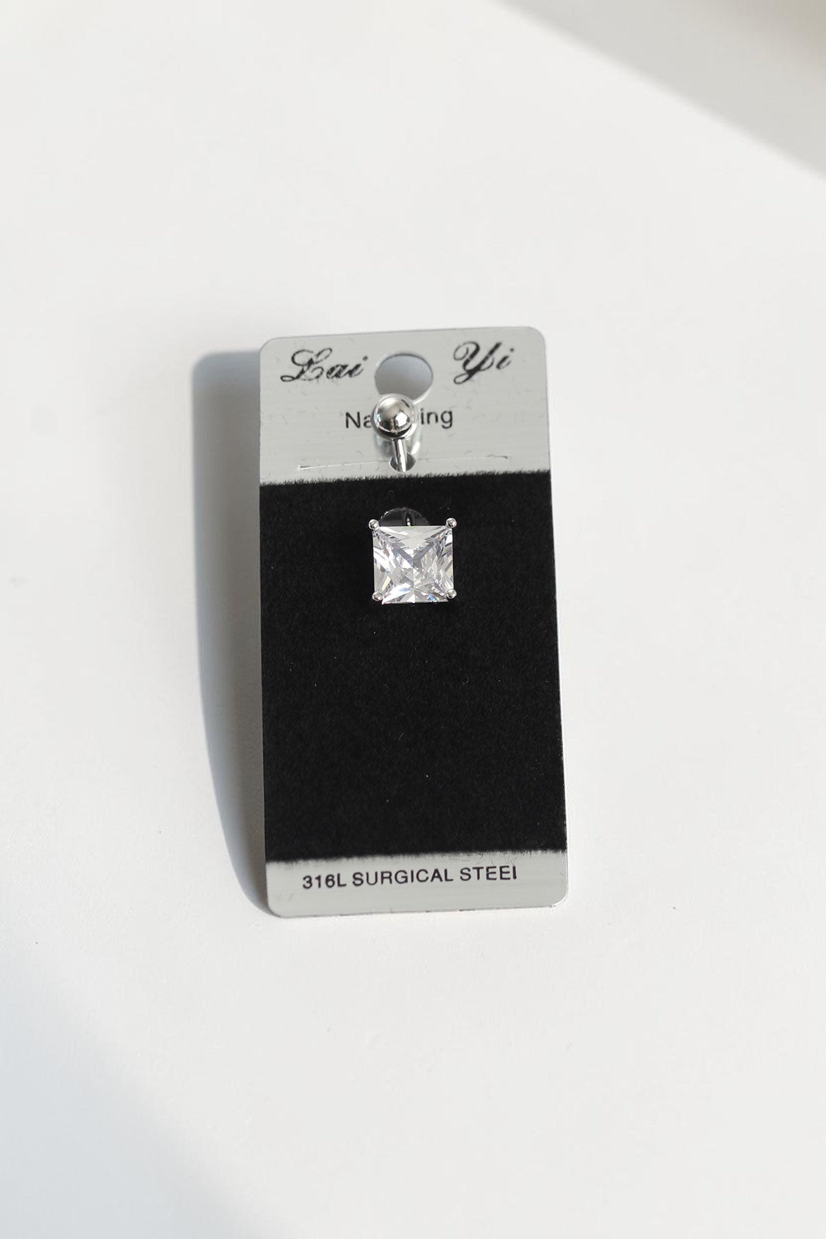 VORA HOUSE square zircon stone belly piercing made of 316L surgical steel on a display card