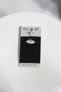 VORA HOUSE 316L surgical steel belly button piercing featuring a silver evil eye design with blue and clear zircon