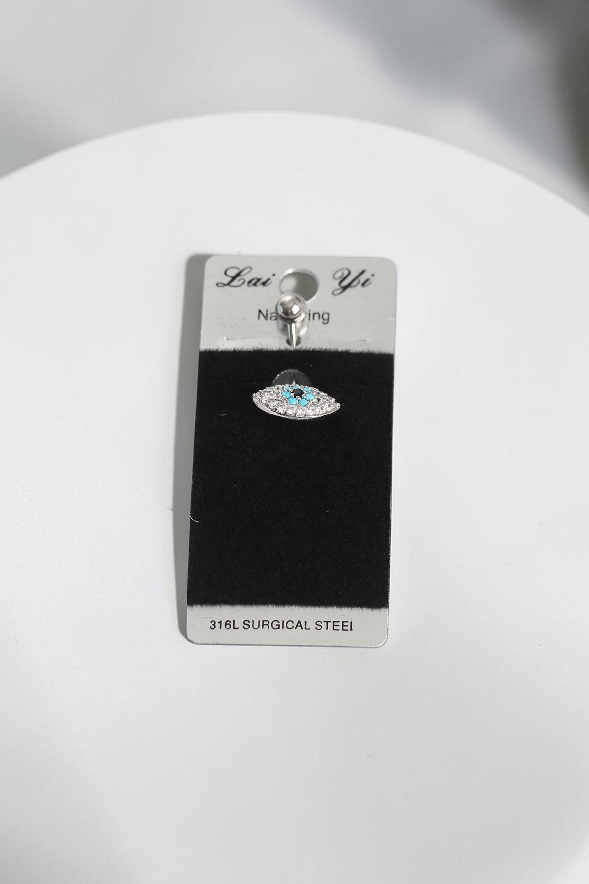 VORA HOUSE 316L surgical steel belly button piercing featuring a silver evil eye design with blue and clear zircon