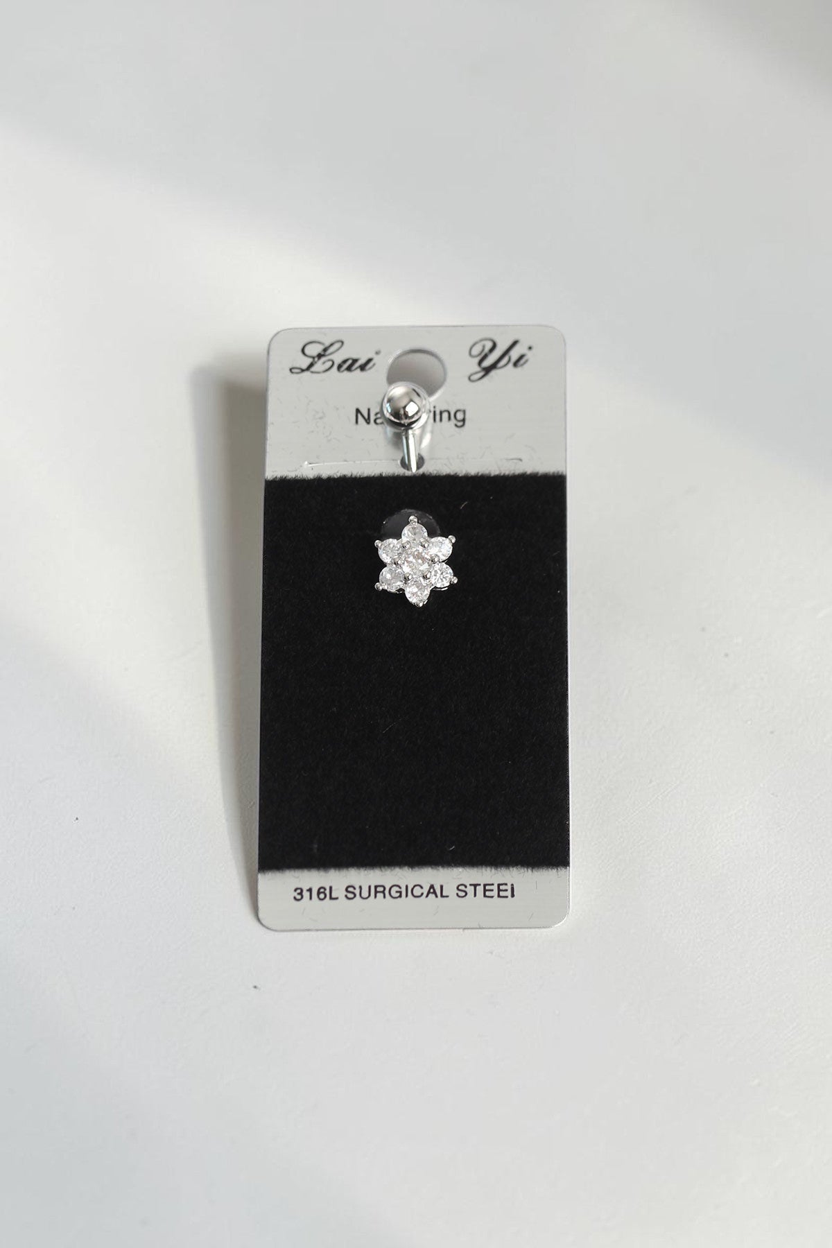 VORA HOUSE 316L surgical steel belly button piercing featuring a sparkling flower design with clear zircon stones.